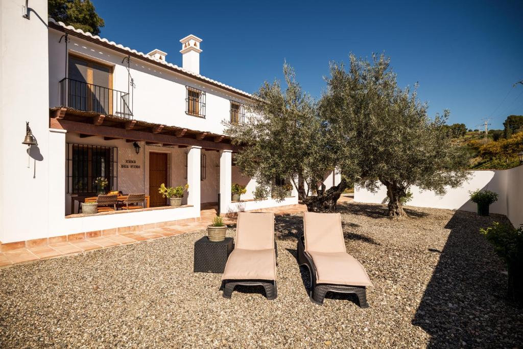 twee stoelen en een tafel voor een huis bij Casa del Pino in Pizarra