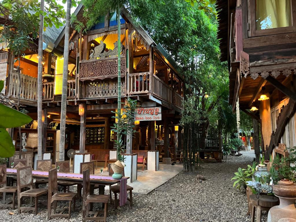 
a restaurant with tables, chairs, tables and umbrellas at Baan Boo Loo Village- SHA Plus in Chiang Mai
