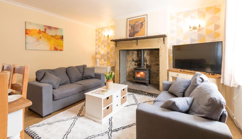 a living room with two couches and a fireplace at Potters Retreat in Alnwick