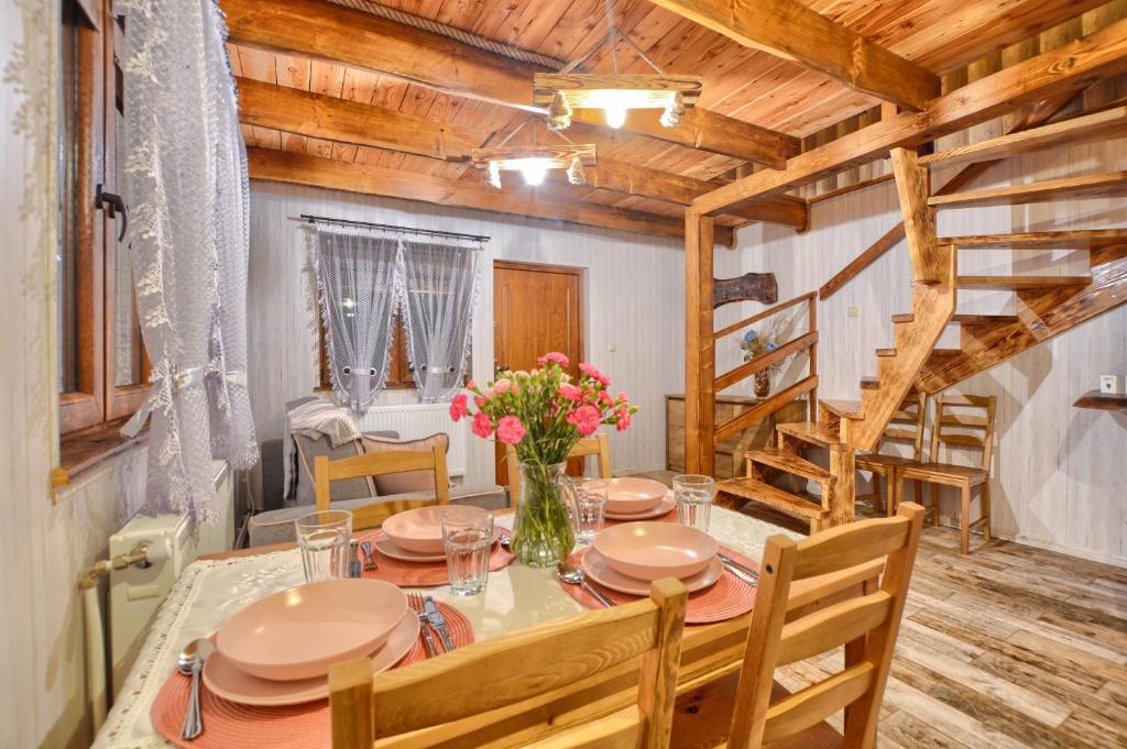 a dining room with a table and chairs and a staircase at Ostoja Bieszczady in Lutowiska