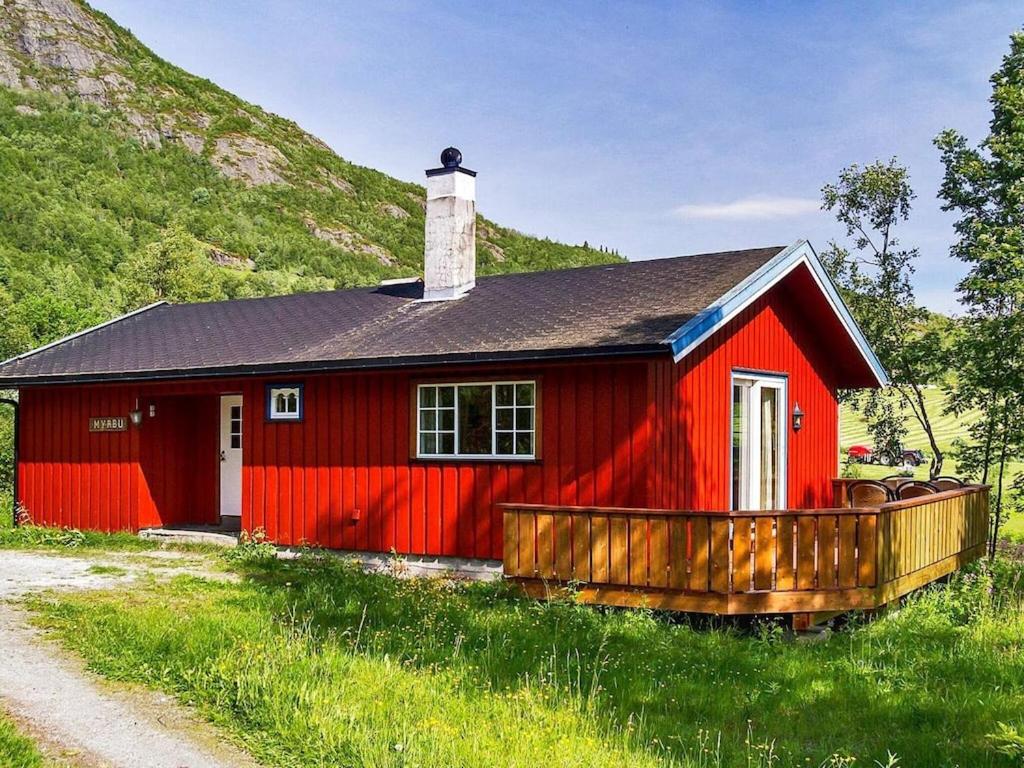 a red house with a black roof in a field at 7 person holiday home in Hemsedal in Hemsedal