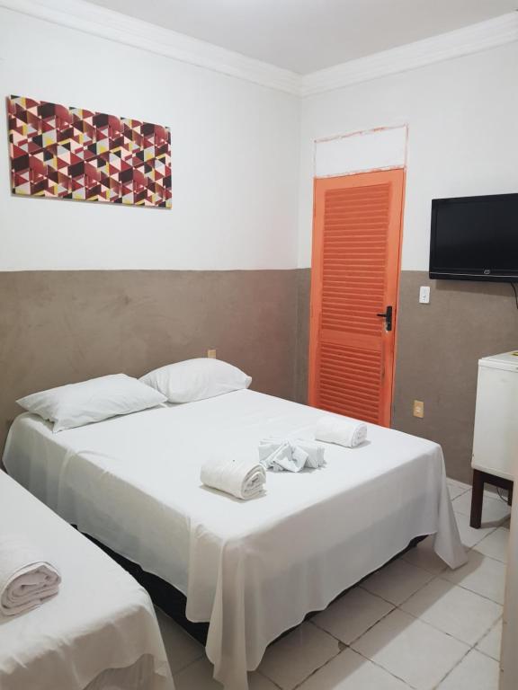 a hotel room with two beds and a television at Pousada Manaíra Buena Playa in João Pessoa