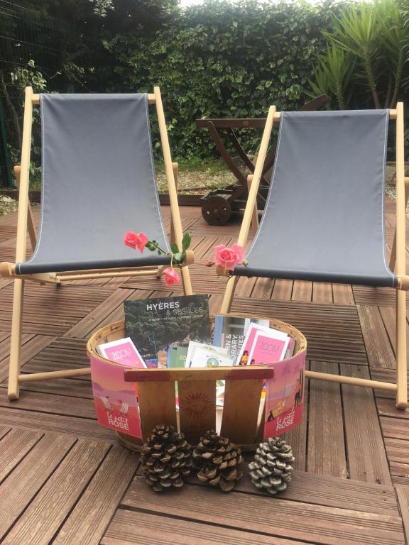 two chairs on a deck with a basket of pine cones at T2 à 2 minutes de la plage in La Londe-les-Maures