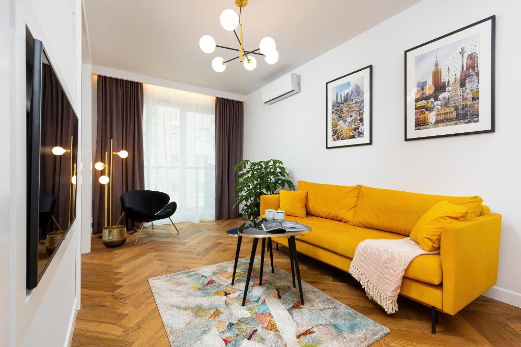 a living room with a yellow couch and a table at Sienna 65 Premium Apartment with Parking in Warsaw by Renters Prestige in Warsaw