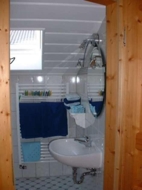 La salle de bains est pourvue d'un lavabo et d'une serviette bleue. dans l'établissement Haus Mayer - Chiemgau Karte, à Inzell