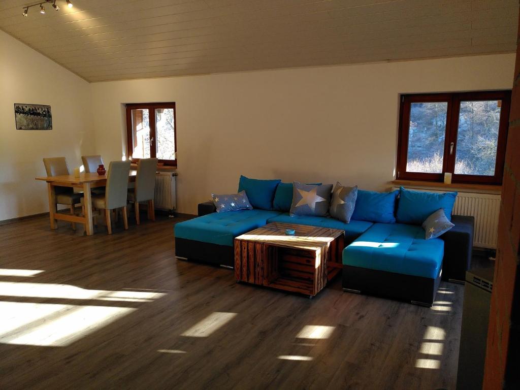a living room with a blue couch and a table at Strandurlaub am Felsenmeer in Modautal