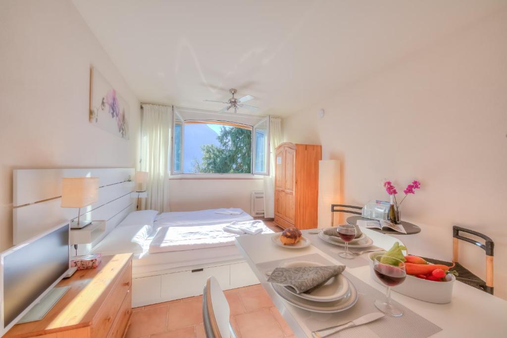 a kitchen with a table with plates and fruit on it at Apartments Gelsomino, Orchidea and Magnolia in Castagnola