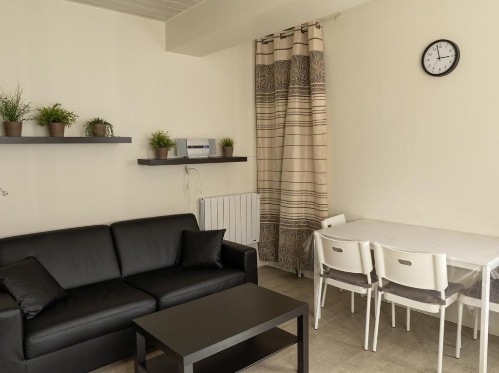a living room with a couch and a table at Appartement Mont Dore face aux Thermes - Centre in Le Mont-Dore