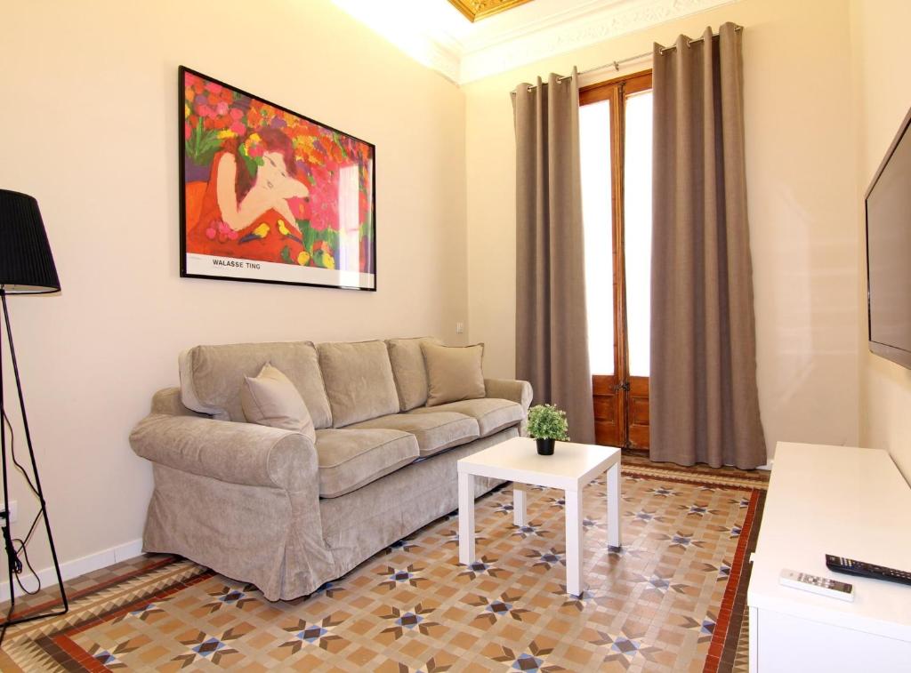 a living room with a couch and a table at GIRONA - Modernist apartments next to Paseo de Gracia in Barcelona