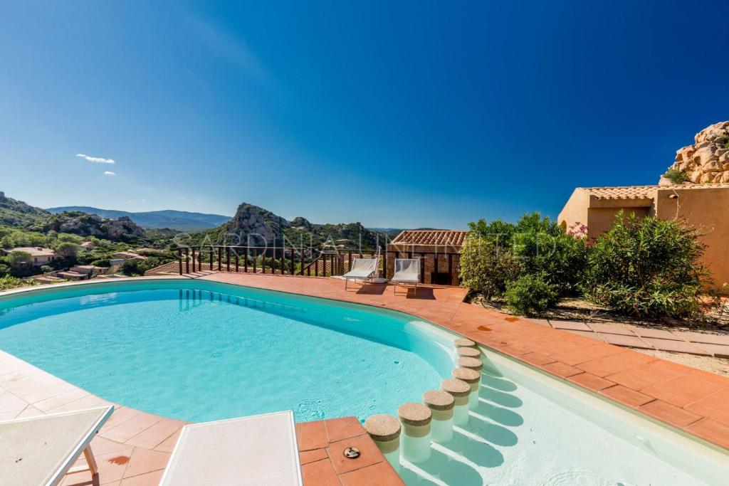 einen Pool mit Blick auf ein Haus in der Unterkunft Violetta Vita in Costa Paradiso