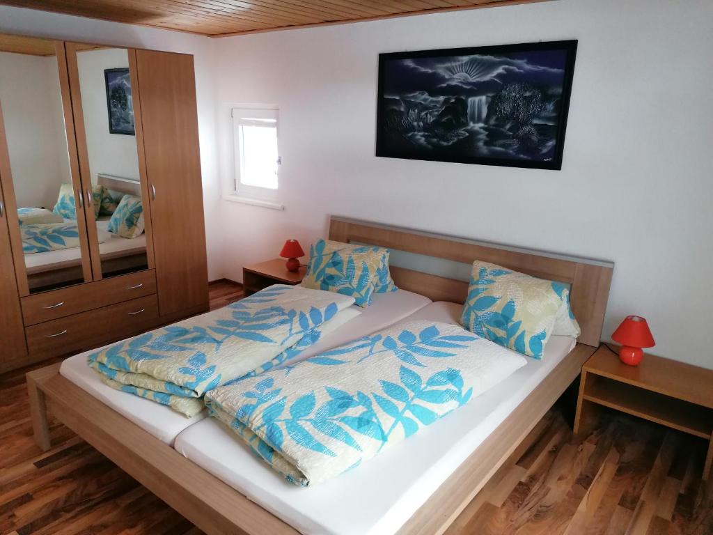 um quarto com uma cama com lençóis azuis e um espelho em Haus Can em Dalaas