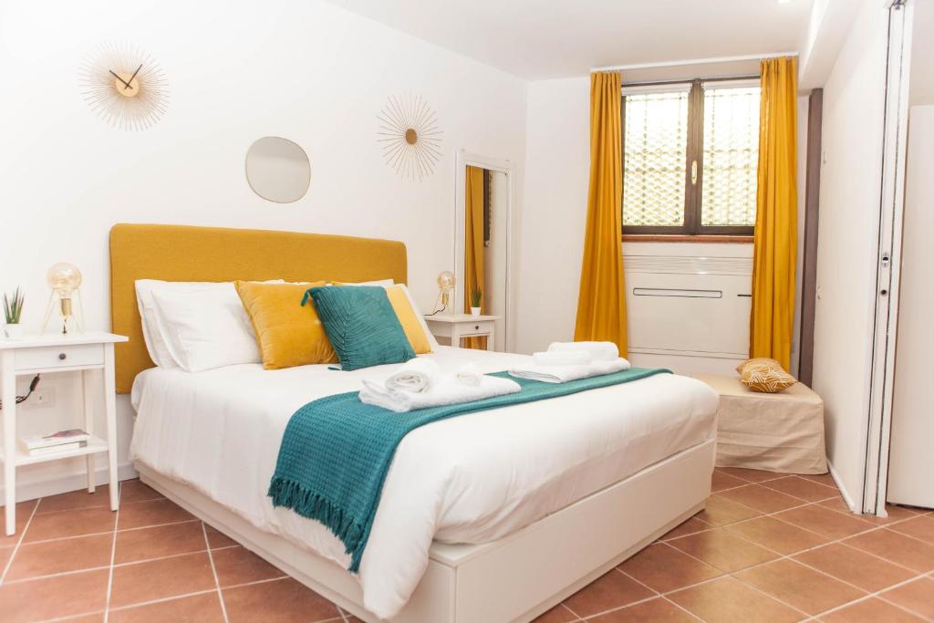 una camera da letto con un grande letto bianco con cuscini colorati di Domina Trastevere Apartment - Roma a Roma