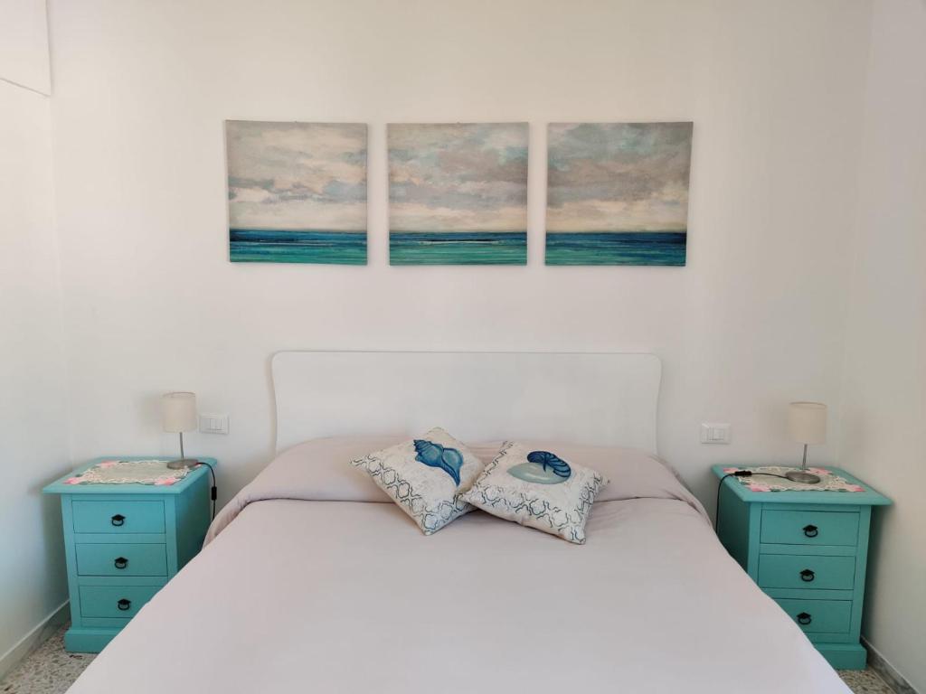 1 dormitorio con 2 mesitas de noche azules y 1 cama en Casa Atena, en Sperlonga