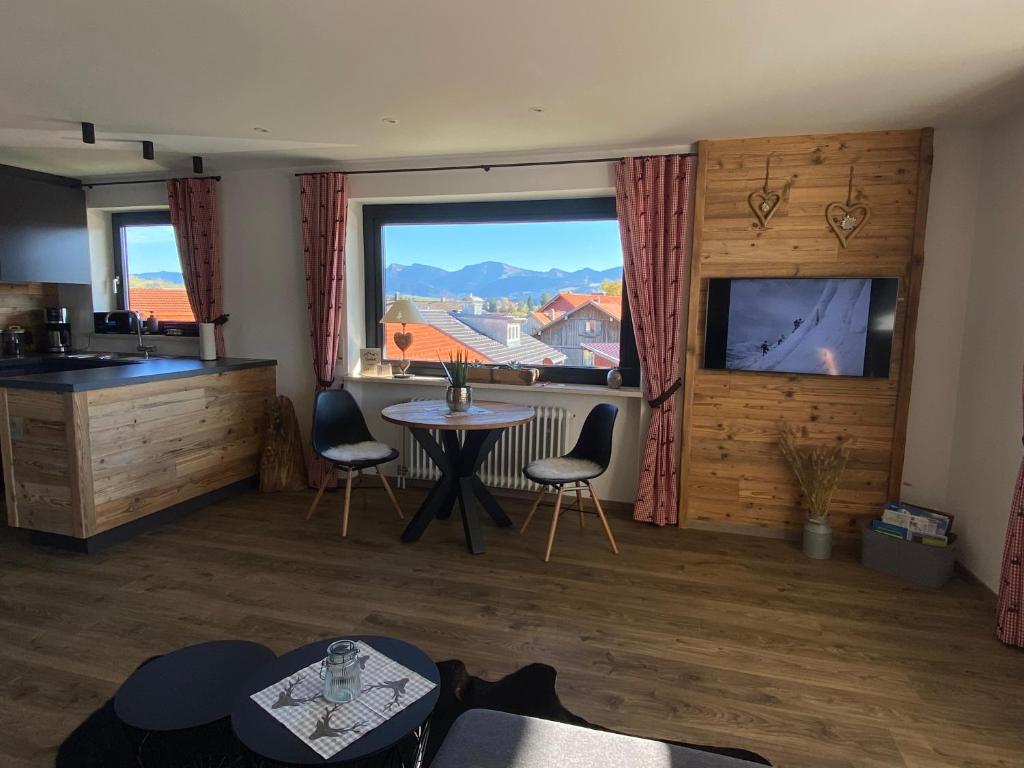 a living room with a table and chairs and a large window at Ferienwohnung Hochgratglück in Oberreute