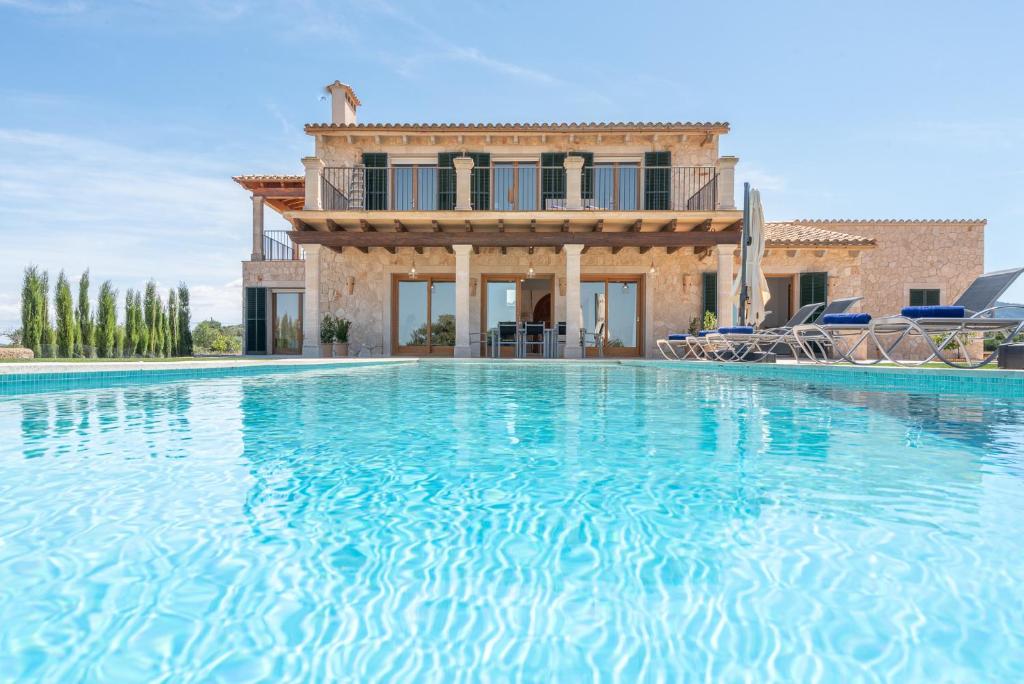 eine Villa mit einem Swimmingpool vor einem Haus in der Unterkunft Finca Sa Era by Mallorca House Rent in Felanitx