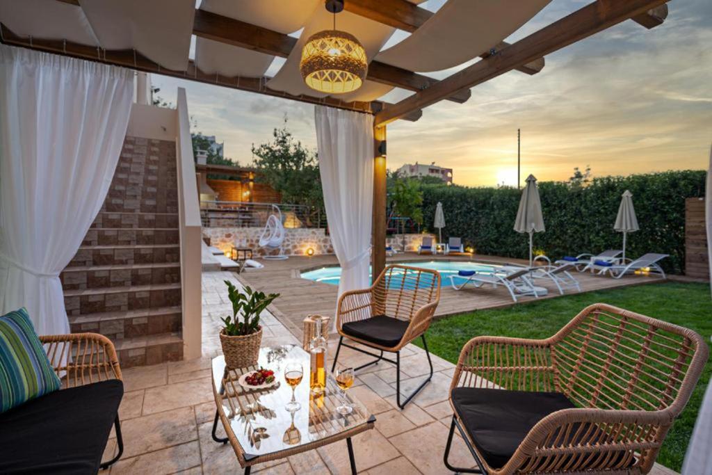 a patio with a table and chairs and a pool at Villa Ellovos with Private Pool in Rethymno Town