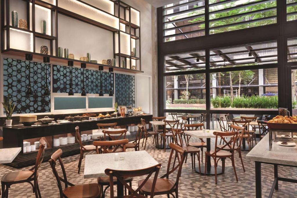 A bright breakfast dining room with buffet counters and café-style tables.