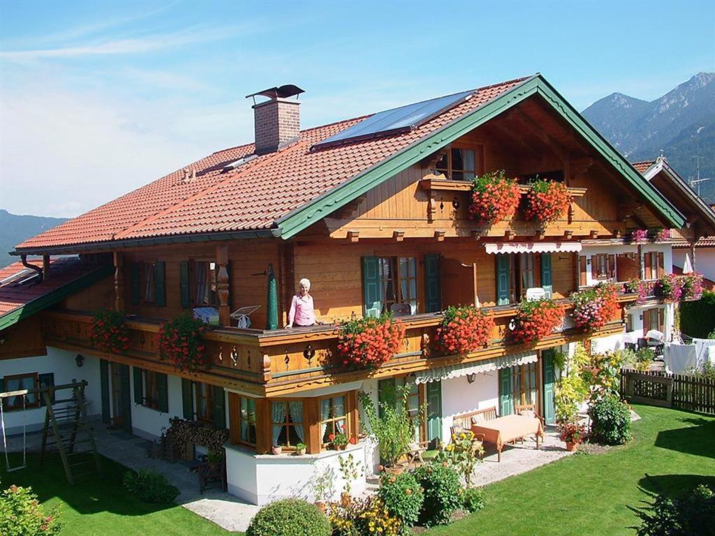 a woman standing on the balcony of a house at Landhaus Gschwand in Krün