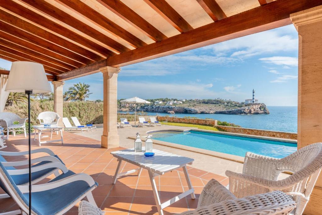 un patio avec une table et des chaises et une piscine dans l'établissement Villa Front a Far, à Portocolom
