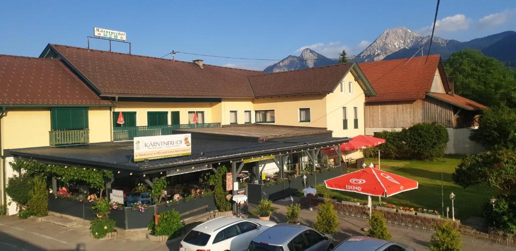 an overhead view of a building with cars parked in front at Gasthaus - Pension Kärntnerhof in Faak am See