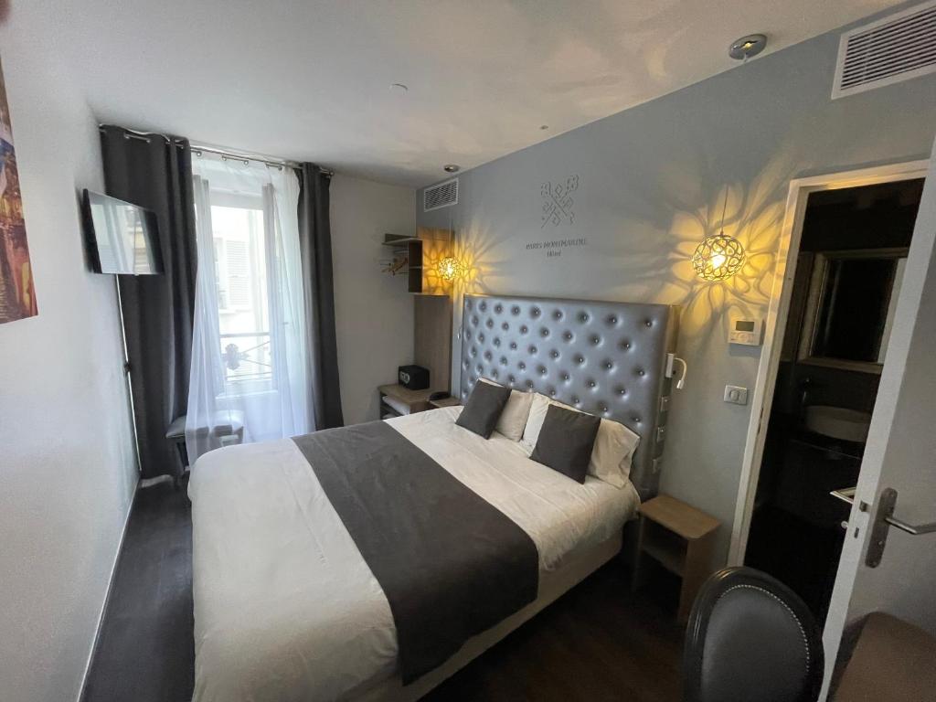 - une chambre avec un grand lit dans l'établissement Hotel de Paris Montmartre, à Paris