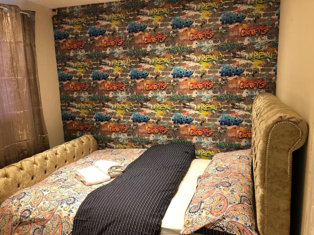 Nice 3-Bed House in Farnham Royal Slough في سلاو: سرير في غرفة مع جدار