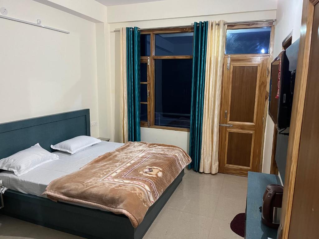 a bedroom with a bed and a large window at Ranas B&B in Shimla