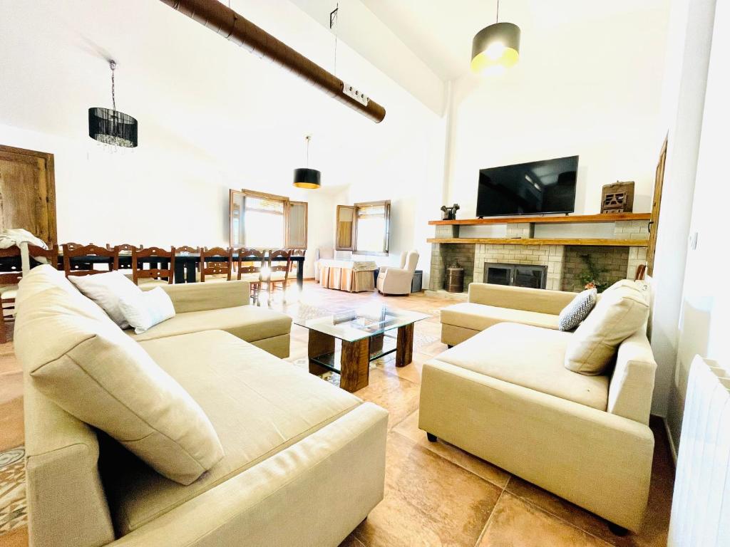 una gran sala de estar con sofás y chimenea. en COMPLEJO RURAL TORRES Y NAVAS, en Granada