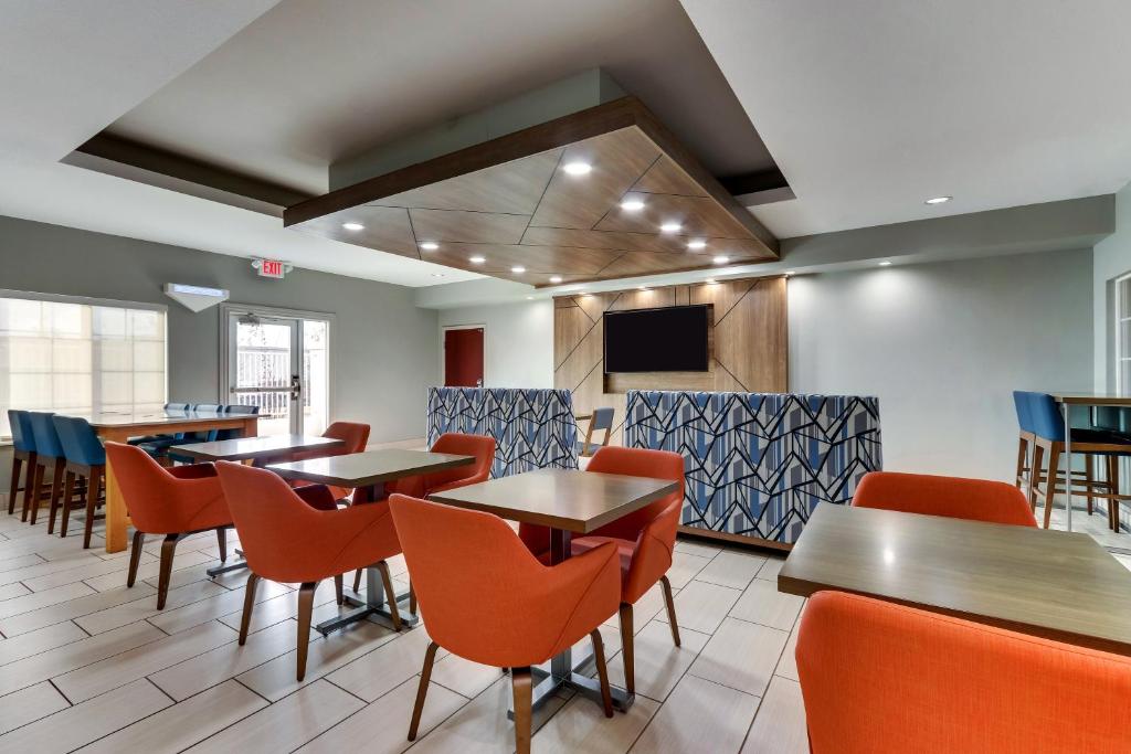 a dining room with tables and chairs and a tv at Holiday Inn Express & Suites - Ardmore by IHG in Ardmore