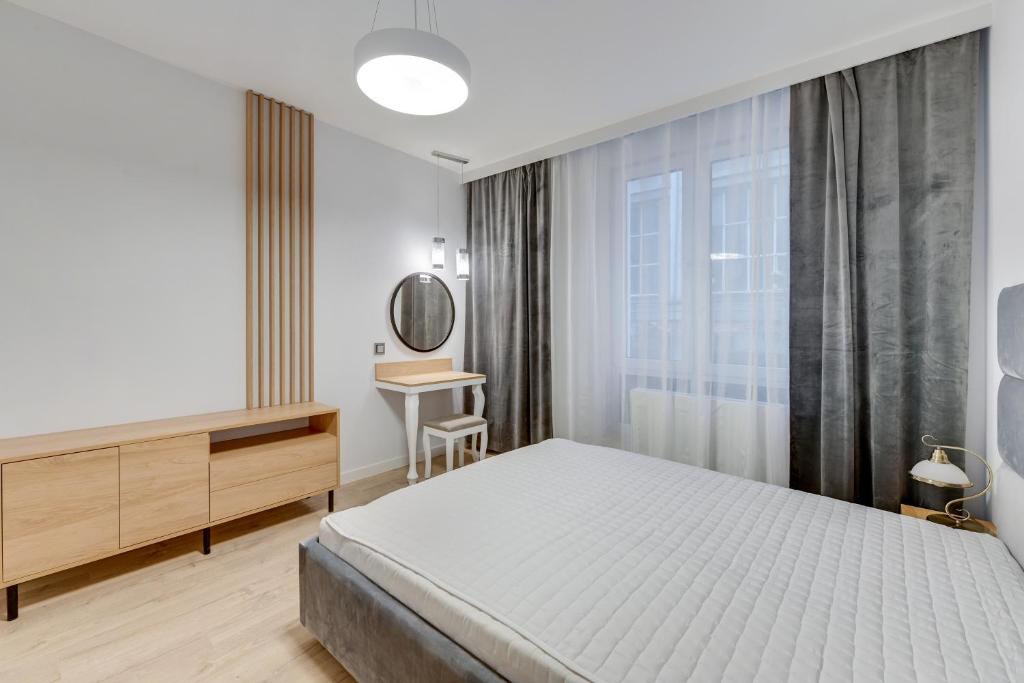 sypialnia z łóżkiem, biurkiem i lustrem w obiekcie Comfort Apartments Wilcza w Gdańsku