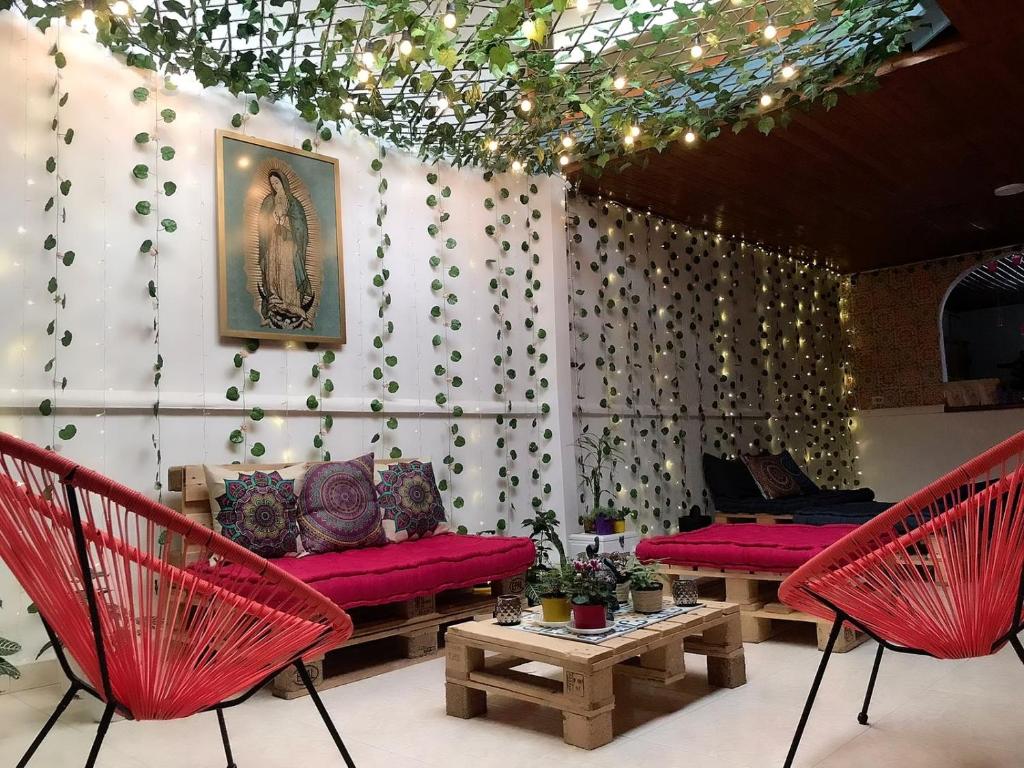 een kamer met rode stoelen, een bank en een tafel bij Hospedaje Casa Rosa Jardín in Jardin