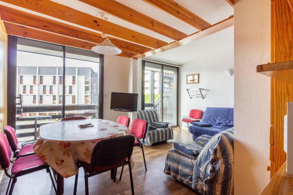 a living room with a table and chairs at L'Altitude - Appartement avec balcon au pied des pistes in Saint-Lary-Soulan