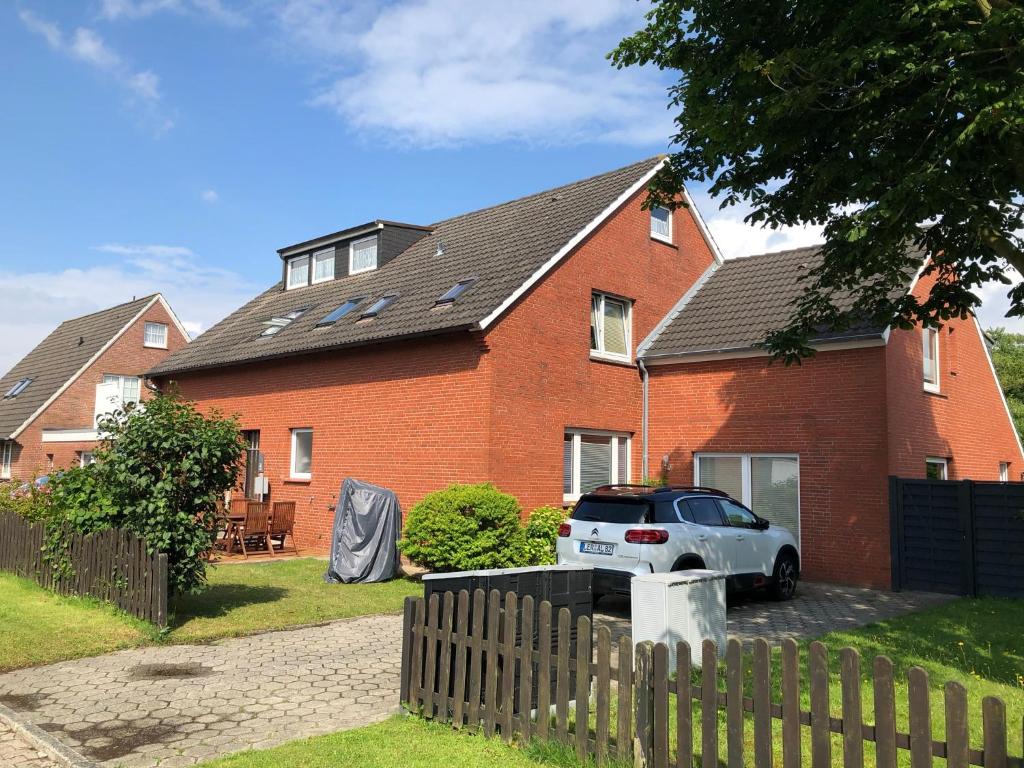 uma casa com um carro estacionado em frente em Huus Borkum em Borkum