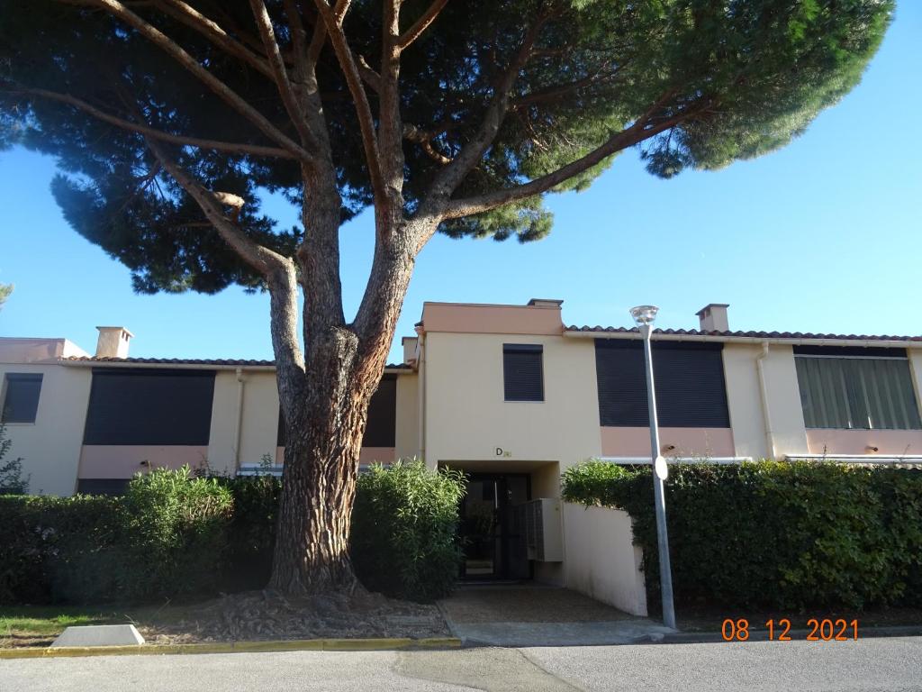 una casa con un albero di fronte di Appartement cosy à 500m de la mer a Plage dʼArgelès