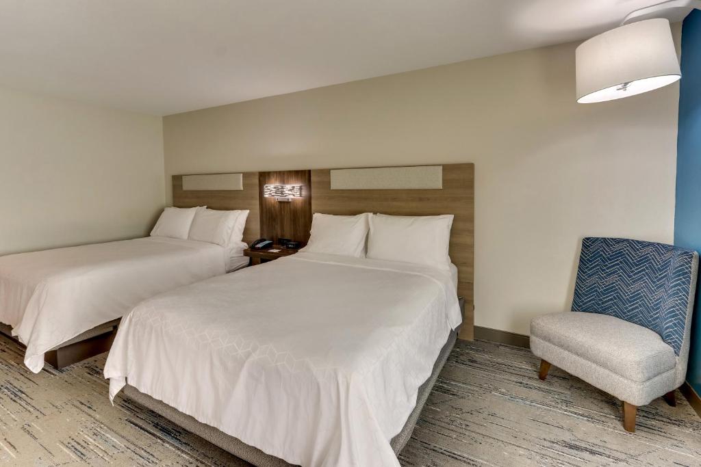 a hotel room with two beds and a chair at Holiday Inn Express & Suites - Ardmore by IHG in Ardmore