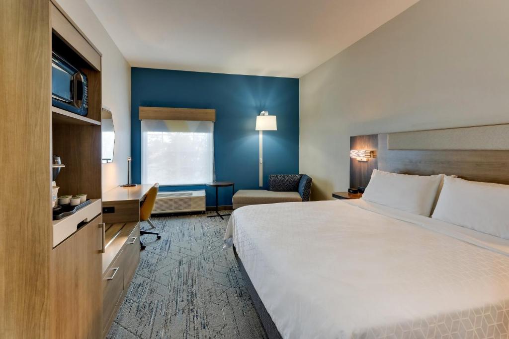 a hotel room with a large bed and a chair at Holiday Inn Express & Suites - Ardmore by IHG in Ardmore