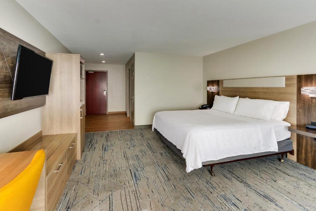 a hotel room with a bed and a flat screen tv at Holiday Inn Express & Suites - Ardmore by IHG in Ardmore