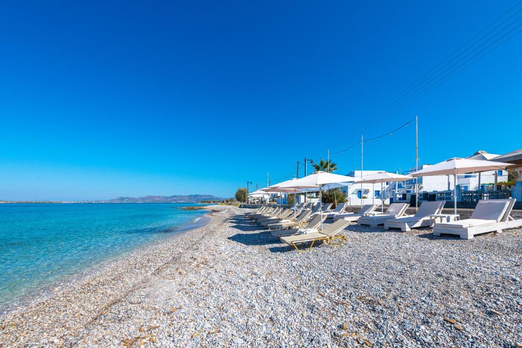 a beach with chairs and umbrellas and the water at Laza Beach in Skala
