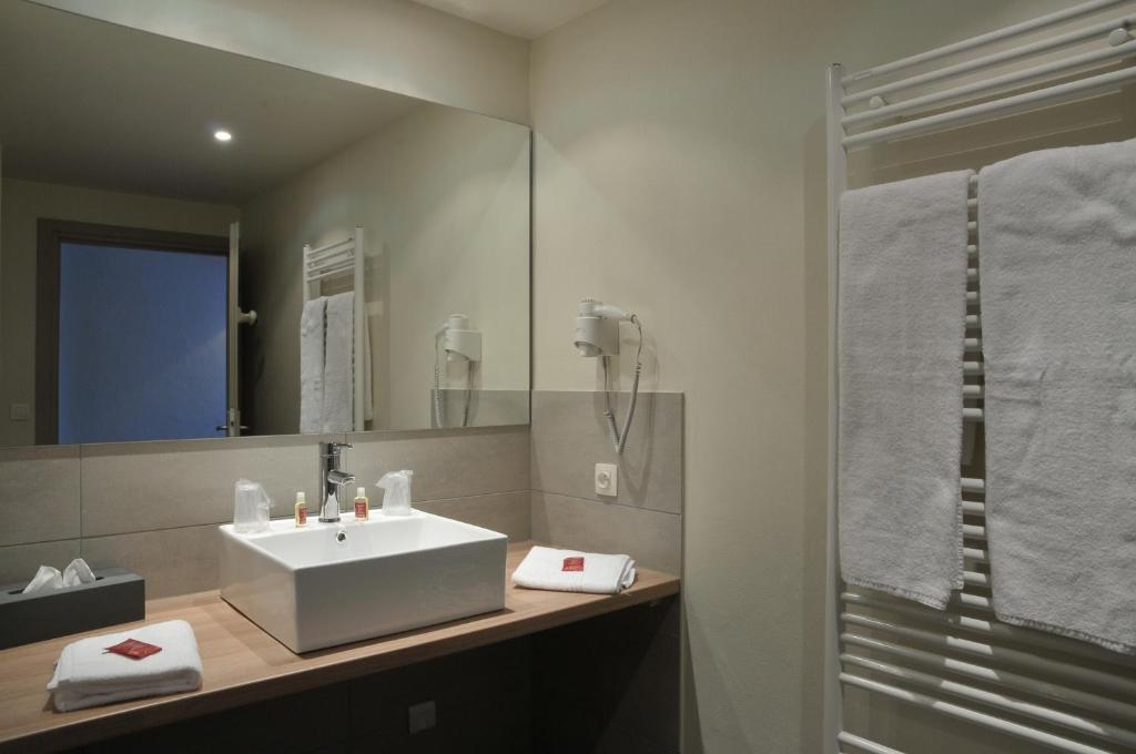 a bathroom with a white sink and a mirror at Hôtel Val d'Este in Saint-Gervais-les-Bains