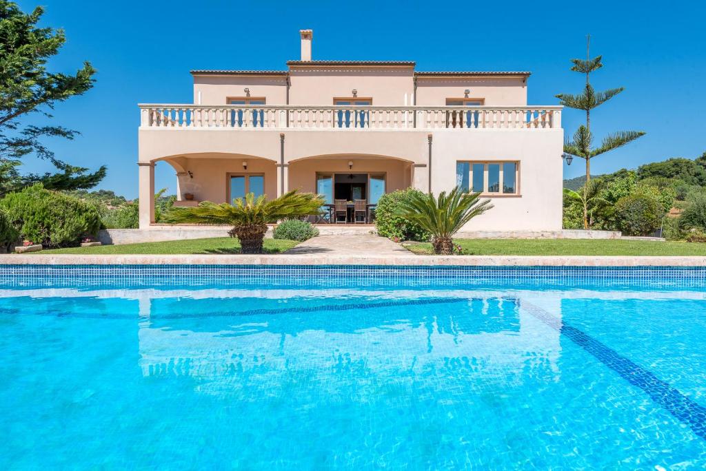 una villa con piscina di fronte a una casa di Es Reguerons Gran a Felanitx