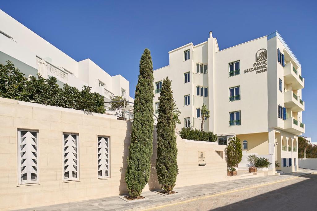 a row of trees in front of a building at Favie Suzanne in Tinos Town