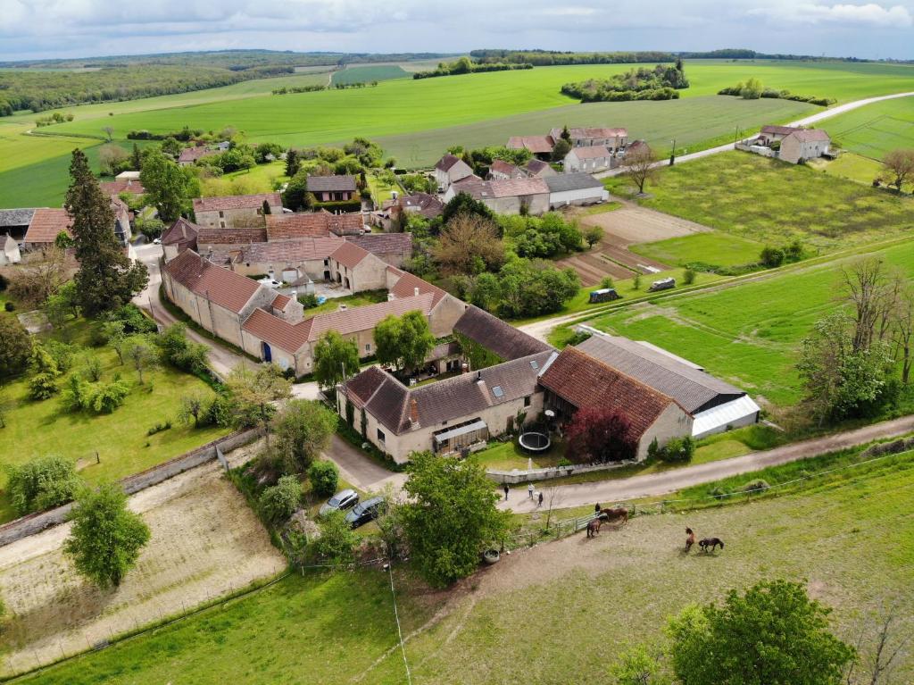 - une vue aérienne sur un village avec des maisons et des chevaux dans l'établissement La Côte Monsieur, à Sanvigné