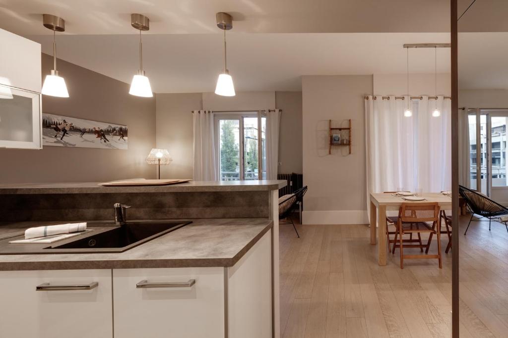uma cozinha com um lavatório e uma sala de jantar em Le Sommeiller - Apartment for 2-4 people with balcony in the center em Annecy