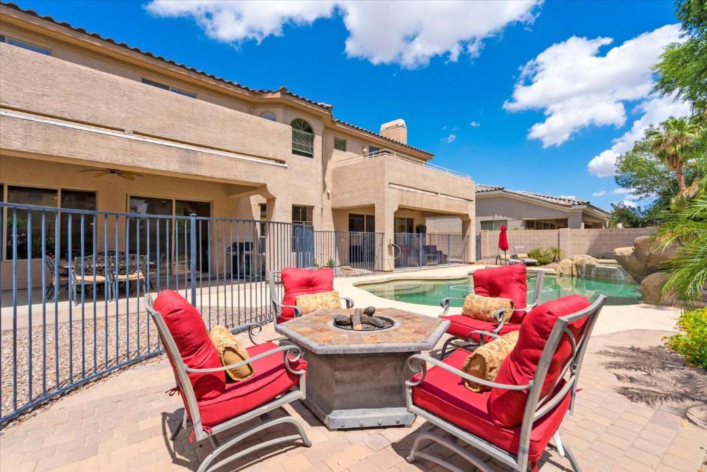 a patio with chairs and a table and a pool at Grand Ironhorse in Queen Creek