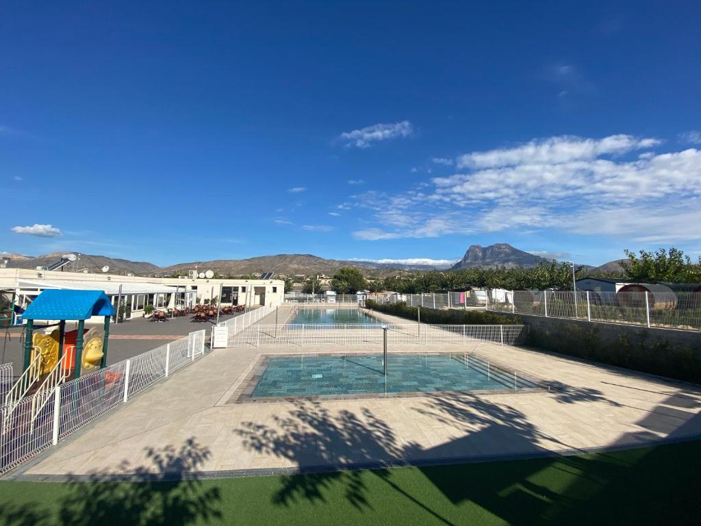 vistas a una piscina con montañas de fondo en Camping Alicante Imperium, en Villajoyosa