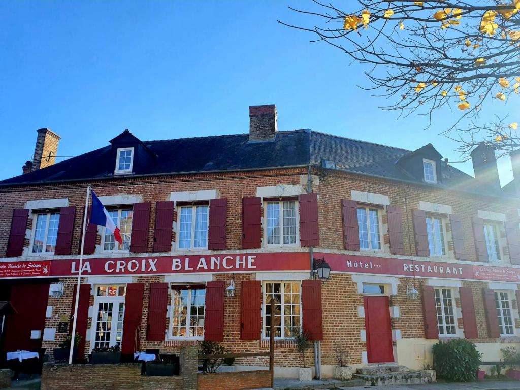 een rood bakstenen gebouw met een bord dat la croix blanche leest bij Croix Blanche de Sologne in Chaumont-sur-Tharonne