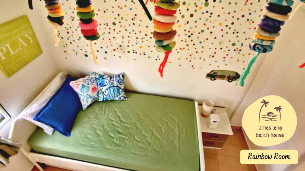 - une chambre avec un lit vert et un mur avec des cerfs-volants dans l'établissement Ames Leng Beach House @ PD 5th Mile, à Port Dickson