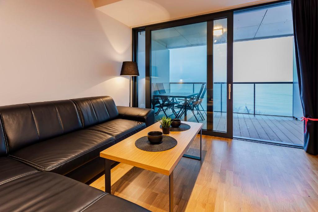 ein Wohnzimmer mit einem Sofa und einem Tisch in der Unterkunft VacationClub – Seaside Apartament 506 in Kołobrzeg