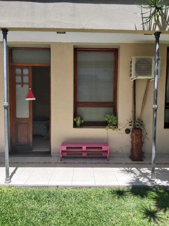 a red bench sitting in front of a house at Taruca Apart in Salta