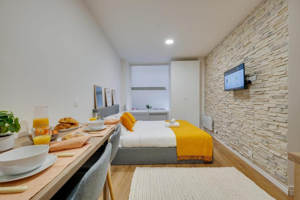 een slaapkamer met een bed en een bakstenen muur bij Charming & welcoming flat next to Tost beautiful places in Paris Museum of modern art Quai Branly Museum in Parijs